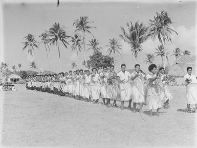 [Large group of Pacific Island men and women possibly performing]