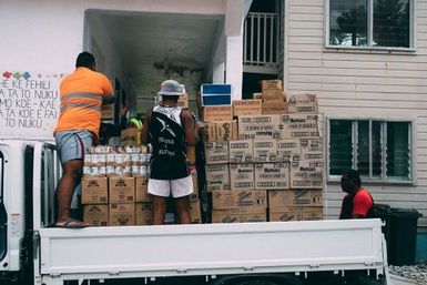 Three men unloading imported goods from a truck, Fakaofo, Tokelau