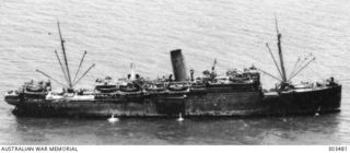 1944-02-07. AERIAL STARBOARD SIDE VIEW OF THE AUSTRALIAN CARGO VESSEL SS KATOOMBA. A 4 INCH GUN, LIGHT AA GUNS AND AN AA ROCKET LAUNCHER ARE MOUNTED AFT. LIGHT AA GUNS ARE SITED AMIDSHIPS, NEAR THE ..