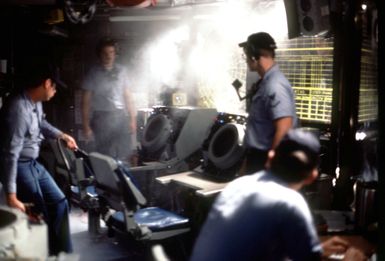 A crewman extinguishes a fire near a radar tracking screen during a drill aboard the amphibous assault ship USS GUAM (LPH 9). (Substandard image)