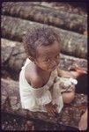 Young girl, Imala, sitting on some logs