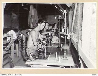 LAE, NEW GUINEA. 1945-11-12. MEMBERS OF 8 SECTION AUSTRALIAN OFFICERS' SHOP, AT WORK IN THE TAILORING DEPARTMENT. IDENTIFIED PERSONNEL ARE:- CORPORAL R.E. GOLDSWORTHY (1); PRIVATE A. LATHOURAS (2); ..