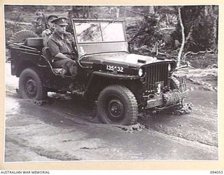 BOUGAINVILLE, 1945-07-16. BRIG J. FIELD, ADMINISTRATIVE COMMAND, HQ 3 DIVISION, TRAVELLING IN A JEEP ALONG THE MUDDY BUIN ROAD EAST OF THE OGORATA RIVER ON HIS WAY TO VISIT HQ 29 INFANTRY BRIGADE