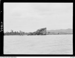 LAE, NEW GUINEA. 1944-03-24. A JAPANESE SHIP SUNK BY THE ROYAL AUSTRALIAN AIR FORCE DURING ENEMY OCCUPATION OF LAE. THE END OF THE LAE AIRSTRIP IS PICTURED IN THE BACKGROUND
