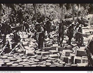 MOROBE, NEW GUINEA. 1943-09-18. AUSTRALIAN TROOPS BOUND FOR LAE WAITING TO BOARD LCT (LANDING CRAFT TANK) NO. 61. NOTE THE RATIONS IN BOXES, SACKS AND DRUMS