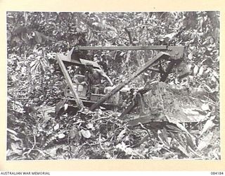 BOUGAINVILLE, SOLOMON ISLANDS. 1944-12-08. LANCE CORPORAL F. TREEN, (1), WORKING WITH 5 AND 11 FIELD COMPANY, ROYAL AUSTRALIAN ENGINEERS, TROOPS ATTEMPTS TO FREE A BOGGED BULLDOZER