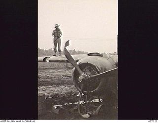 SOPUTA, NEW GUINEA. 1943-09-29. VX90176 SERGEANT R. J. BUCHANAN, PHOTOGRAPHER MILITARY HISTORY SECTION, TAKING PHOTOGRAPHS OF THE CRASHED MITCHELL BOMBER IN WHICH BRIGADIER R. B. SUTHERLAND WAS ..