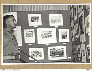 PORT MORESBY, PAPUA, NEW GUINEA. 1943-12-23. DX906 BRIGADIER W. A. B. STEELE, COMMANDER, COMBINED OPERATIONS AND SERVICES COMMAND, AND PORT MORESBY BASE SUB AREA (1) STUDIES THE EXHIBITS AT THE ..