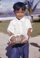Guam, boy holding plate of fish