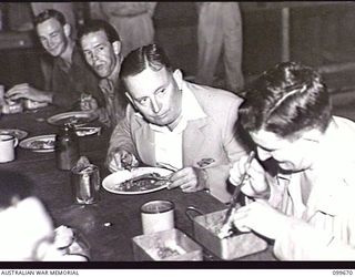 LAE, NEW GUINEA, 1946-01-27. THE HONOURABLE F. M. FORDE, MINISTER FOR THE ARMY, HAVING DINNER IN NO 1 MEN'S MESS, HQ FIRST ARMY, DURING HIS INSPECTION TOUR OF AUSTRALIAN UNITS IN THE AREA