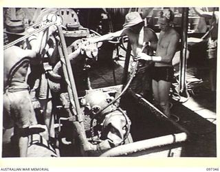 RABAUL, NEW BRITAIN. 1945-09-30. DIVER J. DALLEY COMING UP FROM HOLD AT THE STERN OF THE JAPANESE TANKER NO. 5301 AFTER INSPECTION. THE VESSEL, WHICH WAS SUNK BY ALLIED BOMBERS TWELVE MONTHS AGO, ..