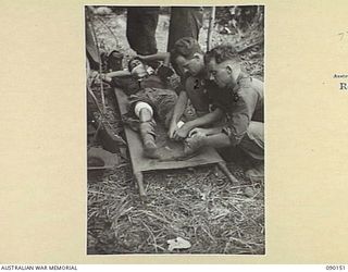 DAGUA, NEW GUINEA. 1945-03-27. 2/2 INFANTRY BATTALION STRETCHER BEARERS CARRYING THE WOUNDED FROM A FORWARD PATROL TO A COMPANY HQ, RENDER ASSISTANCE TO SGT V. AUSTIN (1), WHO WAS BADLY WOUNDED IN ..