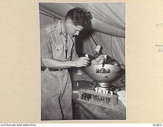 CAPE WOM, WEWAK AREA, NEW GUINEA, 1945-07-11. PRIVATE E. CHALLINOR, FIELD DETACHMENT LAND HEADQUARTERS MEDICAL RESEARCH UNIT, WORKING ON THE CENTRIFUGING OF BLOOD. THE RED AND WHITE CELLS ARE ..