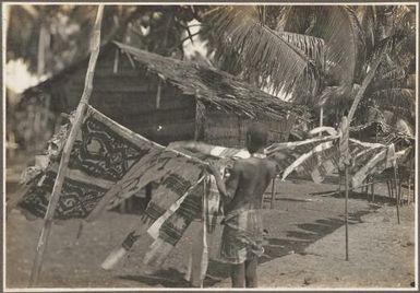 Glimpses around Wanigella [Wanigela], [boy hanging cloth on a line] / Frank Hurley