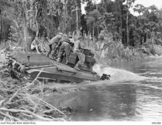 BOUGAINVILLE. 1945-03-30. A B SQUADRON, 2/4 ARMOURED REGIMENT MATILDA TANK CROSSING THE PURIATA RIVER DURING THE ADVANCE FROM TOKO ALONG THE MAIN BUIN ROAD. IDENTIFIED PERSONNEL:- TPR D.M. HOPKINS ..