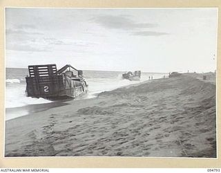 TOROKINA AREA, BOUGAINVILLE, 1945-08-06. DURING AN ATTEMPT TO RE-FLOAT A STRANDED AUSTRALIAN LANDING CRAFT, A SECOND LANDING CRAFT FOULED ITS SCREWS WITH THE HAWSER AND WAS ALSO WASHED ASHORE. AN ..