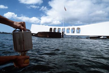 A close-up view of a canister containing the remains of a crew member of the battleship USS ARIZONA (BB 39). The remains will be committed to the submerged battleship by dropping the canister into an opening in the vessel's submerged hull during a memorial service at the USS ARIZONA MEMORIAL