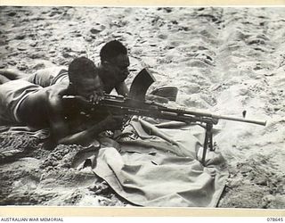BOUGAINVILLE ISLAND. 1945-01-25. TROOPS OF "A" COMPANY, 1ST NEW GUINEA INFANTRY BATTALION FIRING A BREN GUN AT A TARGET FLOATING IN THE SEA