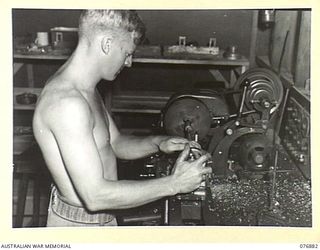 LAE AREA, NEW GUINEA. 1944-11-15. QX37796 SERGEANT N. FENNER MACHINING A CRANKSHAFT JOURNAL ON A 5" "ATLAS" LATHE IN THE MACHINE SHOP OF THE 2/7TH ADVANCED WORKSHOPS