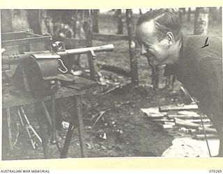DUMPU, RAMU VALLEY, NEW GUINEA, 1944-02-10. NX108697 WARRANT OFFICER II, E.L. MARTIN, OF 129 BRIGADE GROUP WORKSHOPS CHECKING WEAPONS OF THE 57/60TH INFANTRY BATTALION