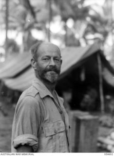 GILI GILI, NEW GUINEA, 1943-07-15. V12787 SAPPER A. A. BURROWS OF THE WATER TRANSPORT UNIT (SMALL CRAFT), THE BEARDED SKIPPER OF A SMALL LUGGER. SAPPER BURROWS BARTERS WITH THE NATIVES FOR FRESH ..