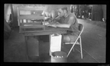 [Servicemen working at desks]