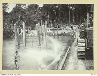 BOUGAINVILLE. 1945-04-23. SAPPERS OF 15 FIELD COMPANY, ROYAL AUSTRALIAN ENGINEERS, HAVE JUST ROLLED A LOG OFF THE OLD MCKINNA BRIDGE DURING RECONSTRUCTION WORK. THEY ARE BUILDING A PANEL BRIDGE ..