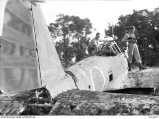 BUT AREA, DAGUA, NORTH EAST NEW GUINEA. C. 1945-05. THESE MEMBERS OF A RAAF PARTY HAD TO GO WELL ARMED AS THE JAPANESE WERE STILL LURKING IN THE JUNGLE NEARBY. THEY ARE STANDING ON THE WING OF A ..