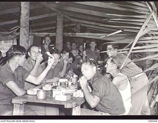 RABAUL, NEW BRITAIN, 1945-12-25. THE NON-COMMISSIONED OFFICERS SERVING CHRISTMAS DINNER TO THE TROOPS AT HEADQUARTERS 37/52ND INFANTRY BATTALION