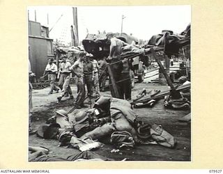 ORO BAY, NEW GUINEA. 1943-07. TROOPS OF THE 10TH FIELD AMBULANCE CARRYING A PATIENT FROM THE USS "KARU MARU" TO AN AMBULANCE FOR TRANSPORT TO THE UNIT MAIN DRESSING STATION