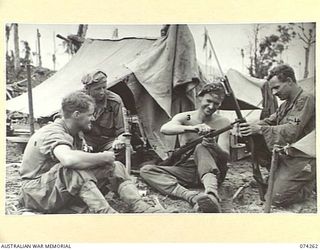 HANSA BAY, NEW GUINEA. 1944-06-22. TROOPS OF C COMPANY, 4TH INFANTRY BATTALION CLEANING UP A JAPANESE SAMURAI SWORD AND JAPANESE RIFLES WHICH THEY CAPTURED DURING THE AUSTRALIAN LANDING IN THE ..