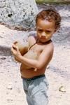Boy cradling two popo (mature coconuts)