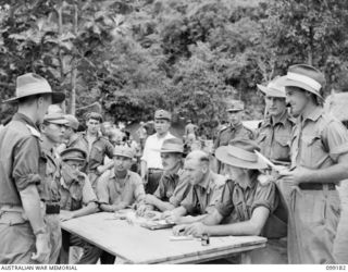 Australian and Chinese officers around a table dealing with the identification of suspected Japanese war criminals by Chinese Army troops