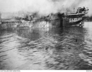 The Dutch transport vessel SS Bantam on fire after being bombed by Japanese aircraft in an air raid at Oro Bay during Operation Lilliput