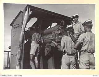 AT SEA, OFF BUIN, BOUGAINVILLE. 1945-08-20. GUNNERS ABOARD THE CORVETTE HMAS LITHGOW TAKING UP ACTION STATIONS AT A 4-INCH GUN AS A JAPANESE BARGE IS SIGHTED AT THE RENDEZVOUS POINT FOR PRELIMINARY ..