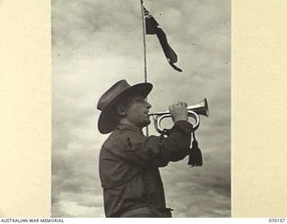 DUMPU, NEW GUINEA. 1944-02-06. VX60958 PRIVATE V. DAVIS (1) SOUNDS "REVEILLE" AS THE FLAG IS RAISED TO FULL MAST AT THE DEDICATION OF THE DUMPU WAR CEMETERY