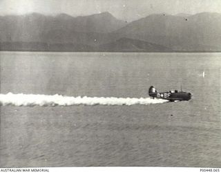 BOUGAINVILLE, PNG. C 1944. COMMONWEALTH AIRCRAFT CORPORATION (CAC) WIRRAWAY OF NO 5 SQUADRON RAAF DEMONSTRATES LAYING A SMOKE SCREEN AT A TROPICAL AIRSTRIP