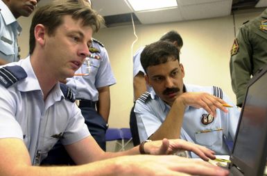 Flight Lieutenant Martyn Silver (left) of the Royal Australian Air Force and Squadron Leaders, B.S. Kanwar, Indian Air Force, review data about operations procedures in preparation of PACIFIC AIRLIFT RALLY 2001 on Andersen Air Forced Base, Guam. PACIFIC AIRLIFT RALLY (PAR) is a PACAF-sponsored military airlift symposium for countries in the pacific region. PAR is held every two years and is hosted by a pacific nation. This year Andersen AFB, Guam is the host nation. The symposium includes informational seminars with area of expertise briefings, a Command Post Exercise (CPX) which addresses military airlift support to a humanitarian airlift/disaster relief scenario, and a concurrent flying...
