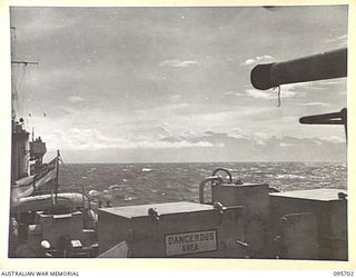 AT SEA OFF RABAUL, NEW BRITAIN. 1945-09-04. IRELAND. 1945-09-04. THE MOUNTAINOUS COASTLINE OF NEW IRELAND LOOMING ABOVE THE CLOUDS AS HMAS VENDETTA PROCEEDS TO A SEA RENDEZVOUS WITH REPRESENTATIVES ..