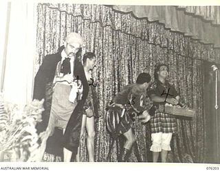 LAE, NEW GUINEA. 1944-09-26. MEMBERS OF THE "TANKS A MILLION" CONCERT PARTY STAGING AN ACT IN THE NEW RECREATION HALL BUILT BY MEMBERS OF THE 22ND WORKS COMPANY AND OFFICIALLY OPENED BY SX21592 ..