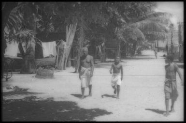 Three men walking in the village : Mortlock Islands, Papua New Guinea, 1960 / Terence and Margaret Spencer