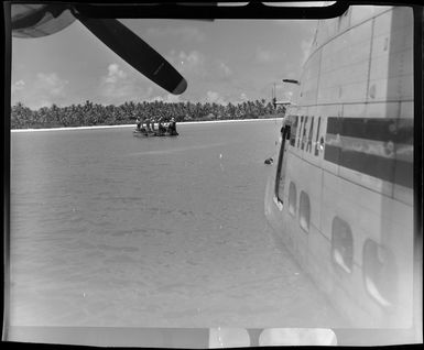 Men on boat with barrels of fuel for TEAL (Tasman Empire Airways Limited) Flying boat, Akaiami, Aitutaki, Cook Islands