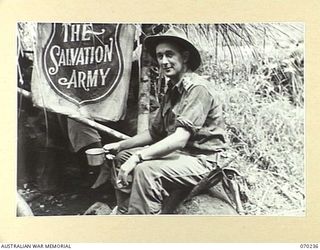 FARIA VALLEY, NEW GUINEA. 1944-02-10. TX2013 LIEUTENANT COLONEL C.J. GEARD, COMMANDING OFFICER OF THE 2/10TH INFANTRY BATTALION, PICTURED DRINKING COFFEE AT THE SALVATION ARMY HUT AT IRIE