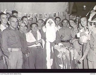 RABAUL,RABAUL, NEW BRITAIN, 1945-12-27. LANCE CORPORAL B. CLAYTON, DRESSED AS SANTA CLAUS, DISTRIBUTED CHRISTMAS PARCELS TO PATIENTS DURING A SOCIAL EVENING GIVEN BY THE AUSTRALIAN RED CROSS TO ..