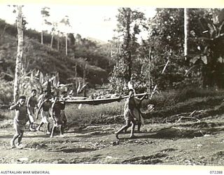 YAULA, NEW GUINEA, 1944-04-10. VX108664 CORPORAL E. ANTHERSON, 57/60TH INFANTRY BATTALION (1), BEING CARRIED BY NATIVE STRETCHER BEARERS TO THE NEAREST ADVANCED DRESSING STATION AT SAIPA NO. 1