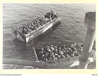 JACQUINOT BAY, NEW BRITAIN. 1945-09-09. TROOPS OF 4 INFANTRY BRIGADE, WAIT IN BARGES ALONGSIDE HMAS MANOORA FOR EMBARKATION. THE MANOORA CARRIED TROOPS FOR THE OCCUPATION OF THE RABAUL AREA, ..