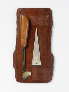 Si'i (weaving tool) and so'so (tool for removing meat from coconuts) mounted on a board