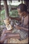 Carving: M'lapokala carving a bowl, probably for tourist trade, he uses an awl with carved wooden handle