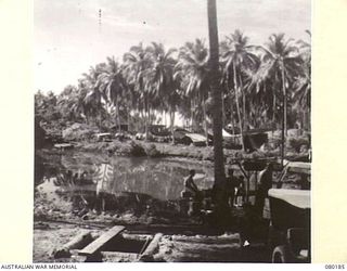 SIAR, NEW GUINEA. 1944-07-07. THE WATER POINT AND HEADQUARTERS 15TH INFANTRY BRIGADE AREA. DEEP WELLS ARE SUNK CAUSING THE WATER TO SEEP THROUGH BY PRESSURE