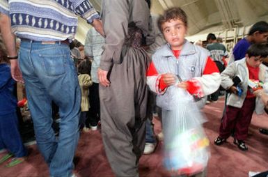 A Kurdish boy holds a bag of toys given to him upon arrival at Anderson Air Force Base, Guam, following an almost 17 hour flight from southern Turkey. Operation PACIFIC HAVEN represents a series of airlifts designed to provide sanctuary for some 2,400 refugees fleeing Iraq. Many are considered traitors by the Iraqi Government for working with the CIA-funded Iraqi National Congress and international humanitarian agencies. The Kurds will be housed at Andersen AFB, while they go through the immigration process for residence in the United States